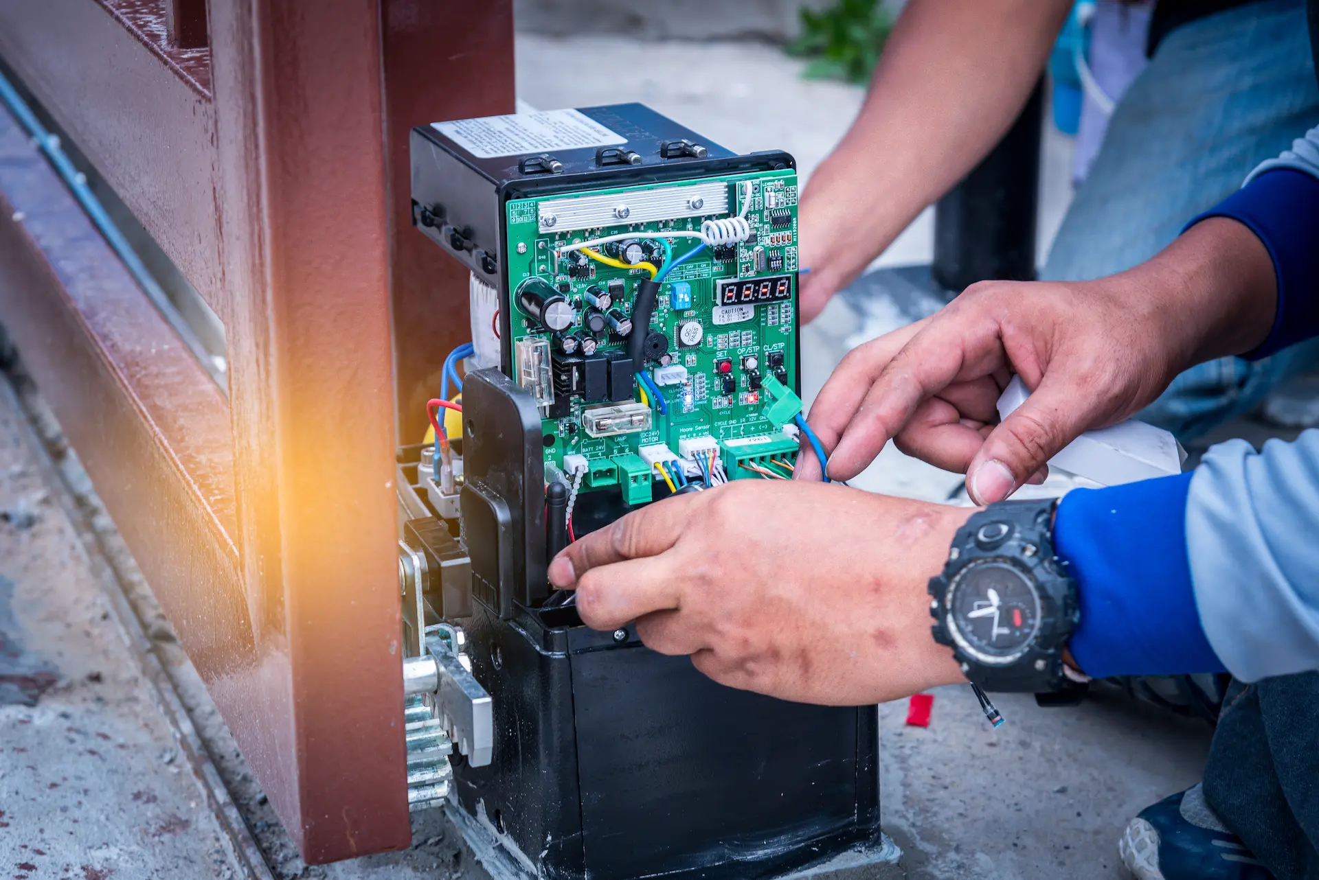 Technician repairing electronic gate circuit board.